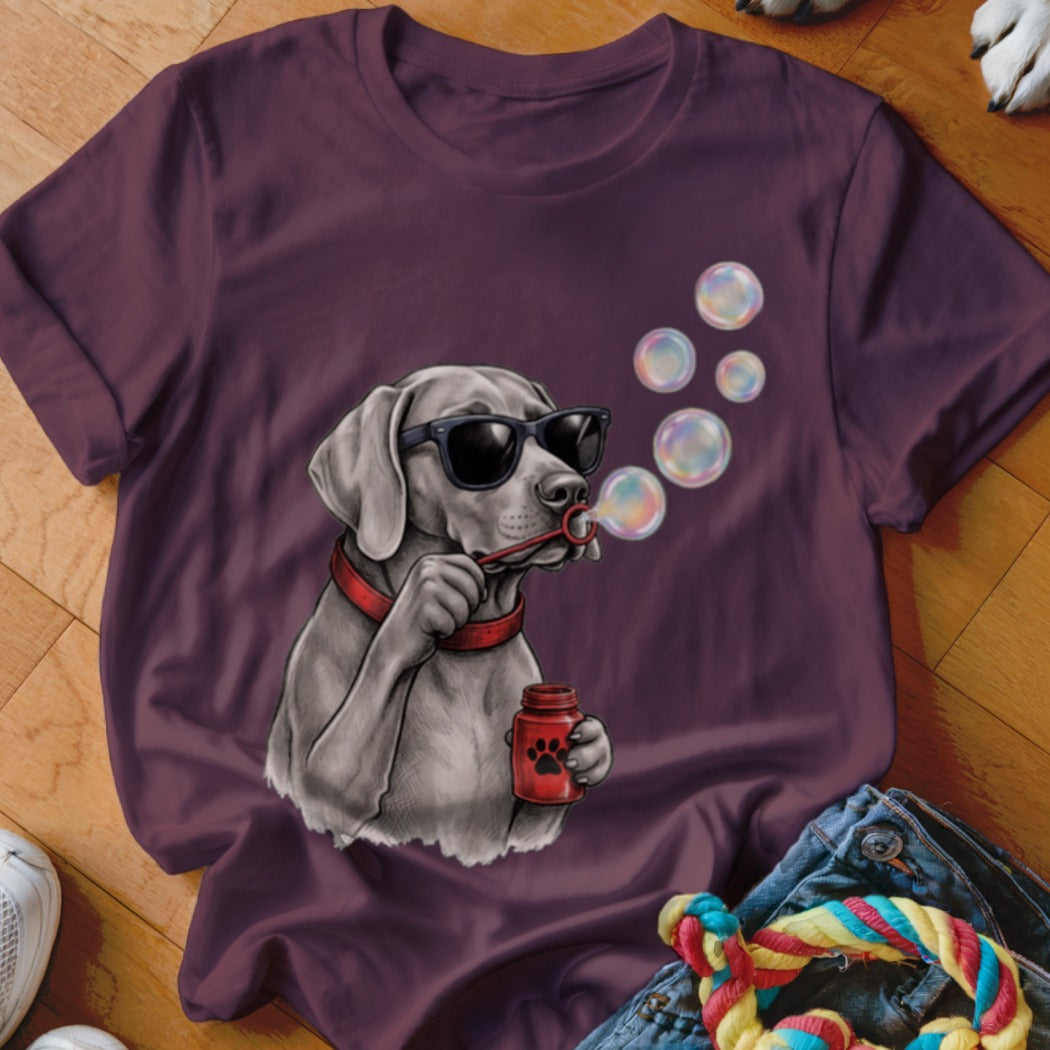 A dark purple crewneck t-shirt featuring a graphic of a dog wearing sunglasses and blowing bubbles.
