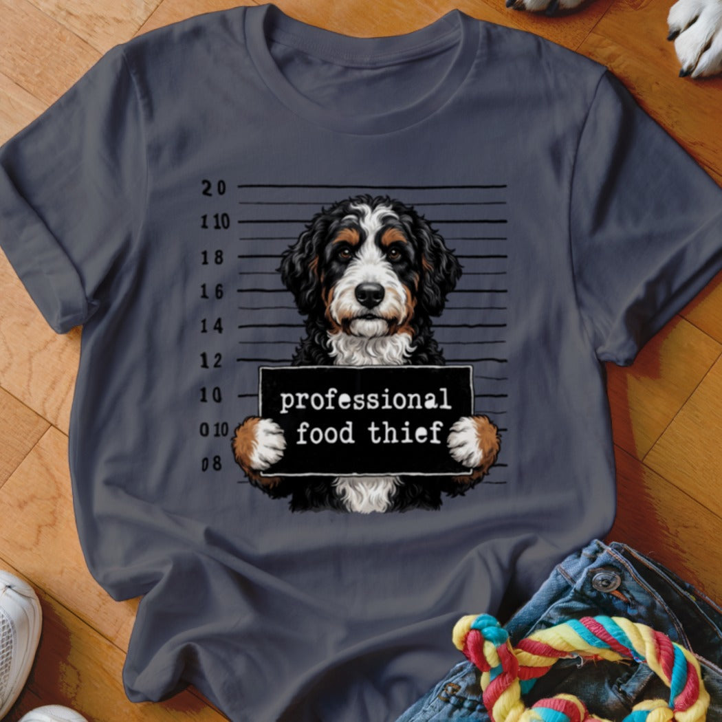Bernese Mountain Dog mugshot with "professional food thief" sign.