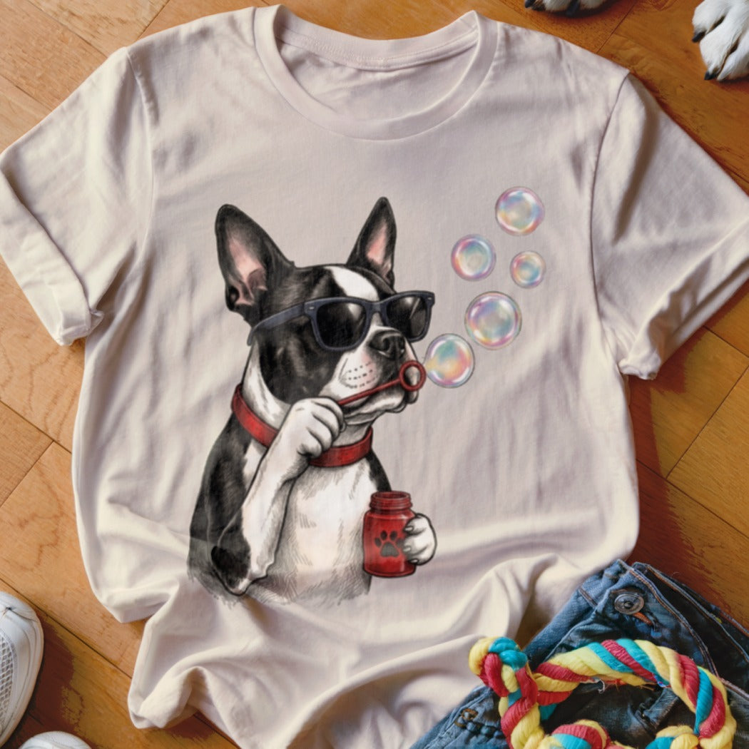 Light cream t-shirt featuring a graphic of a Boston Terrier wearing sunglasses and blowing soap bubbles.