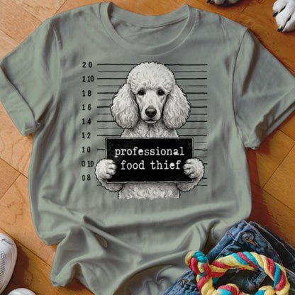 Poodle mugshot with "professional food thief" sign on a light grey t-shirt.