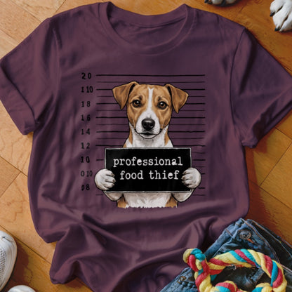 Jack Russell terrier holding a "professional food thief" sign in mugshot style.