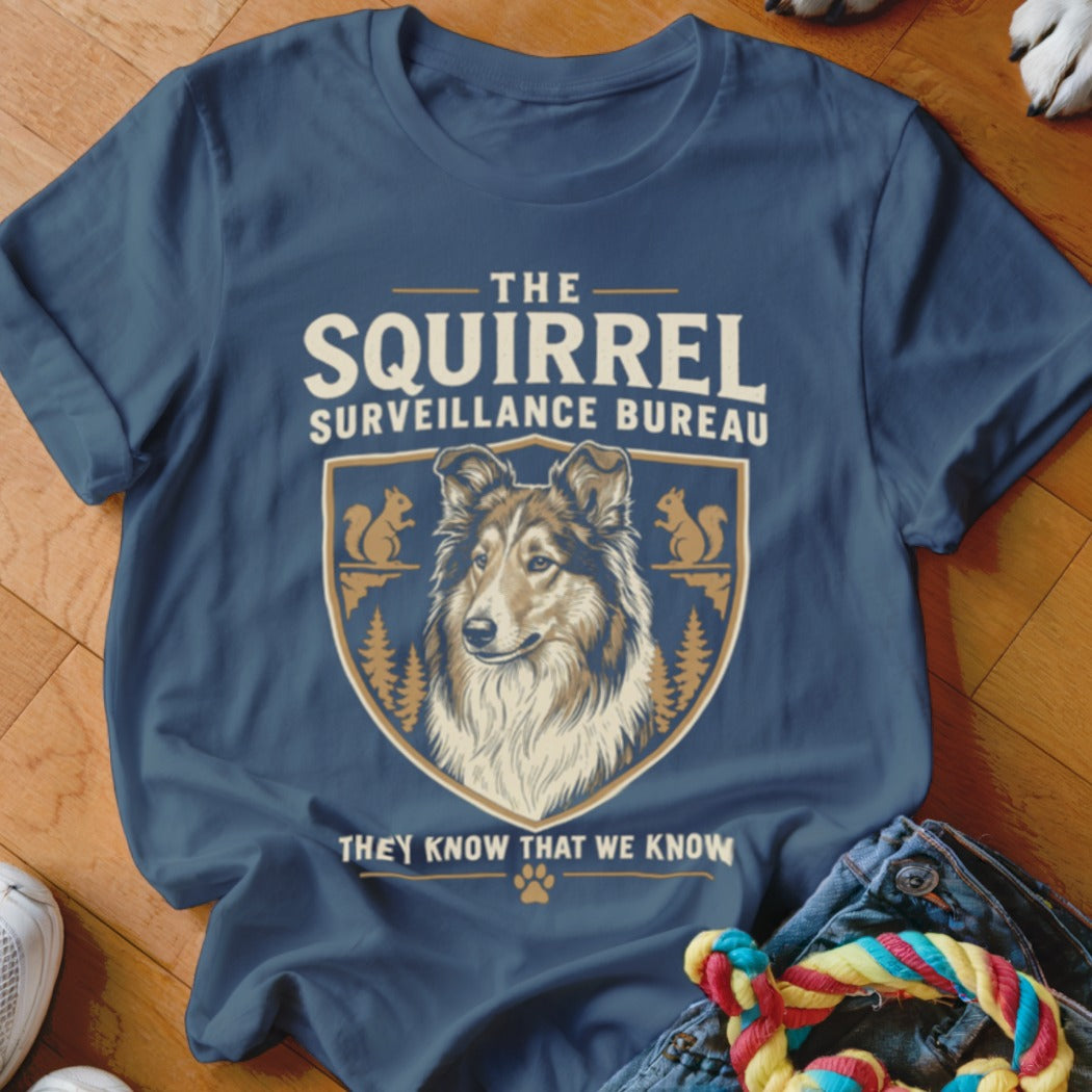 Navy blue t-shirt featuring a crest graphic with a Collie dog and the text The Squirrel Surveillance Bureau.