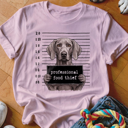 Weimaraner dog mugshot with "professional food thief" sign on a pink t-shirt.