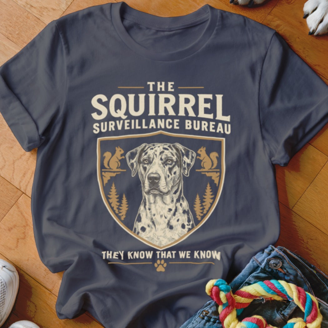 A dark grey t-shirt featuring a graphic design of a Dalmatian inside a crest with squirrels and the text The Squirrel Surveillance Bureau.