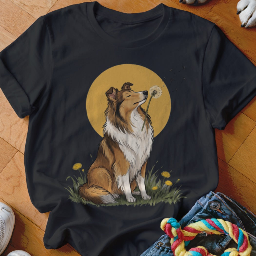 Black t-shirt featuring an illustration of a collie dog blowing a dandelion seed head against a yellow moon.