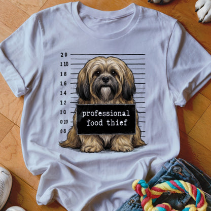Shih Tzu dog in mugshot holding "professional food thief" sign.