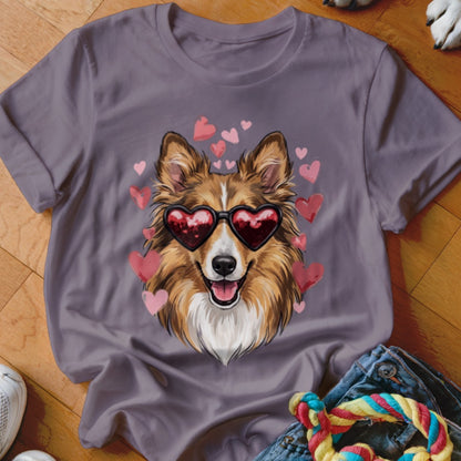Grey t-shirt featuring an illustration of a brown and white dog wearing heart-shaped sunglasses surrounded by pink hearts.