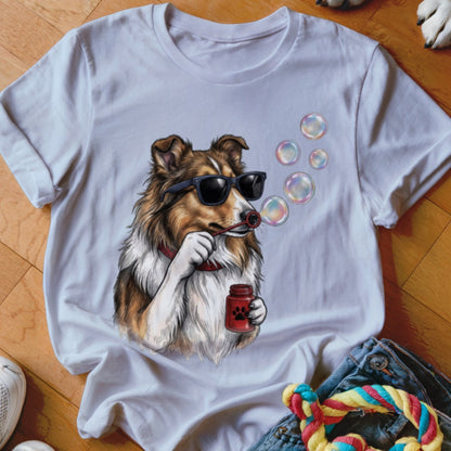 A white t-shirt featuring a graphic of a collie wearing sunglasses and blowing soap bubbles.
