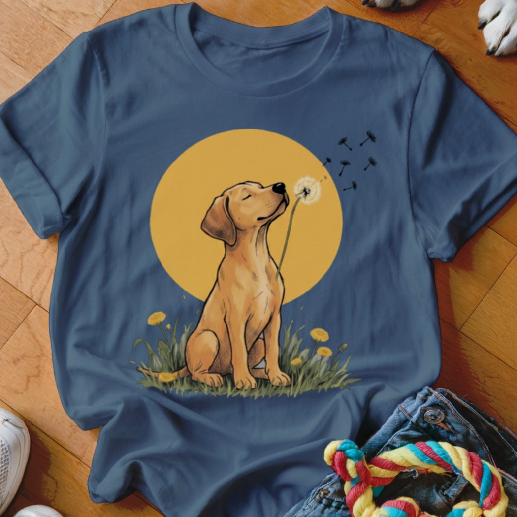 A dark blue t-shirt featuring a graphic of a yellow lab blowing a dandelion.