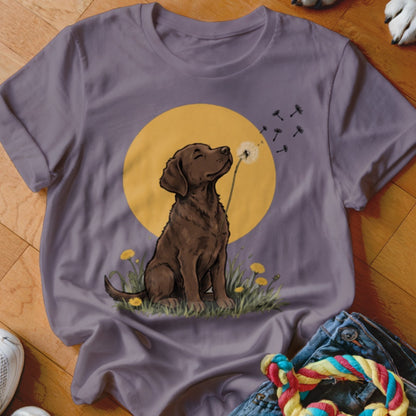 Gray crewneck t-shirt featuring a graphic of a brown dog blowing dandelion seeds against a yellow circle background.