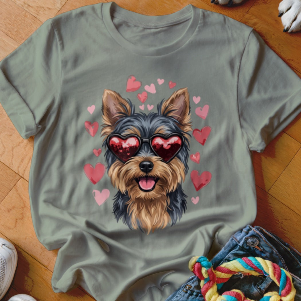 A sage green t-shirt featuring a graphic of a Yorkshire Terrier wearing heart-shaped sunglasses surrounded by pink hearts.