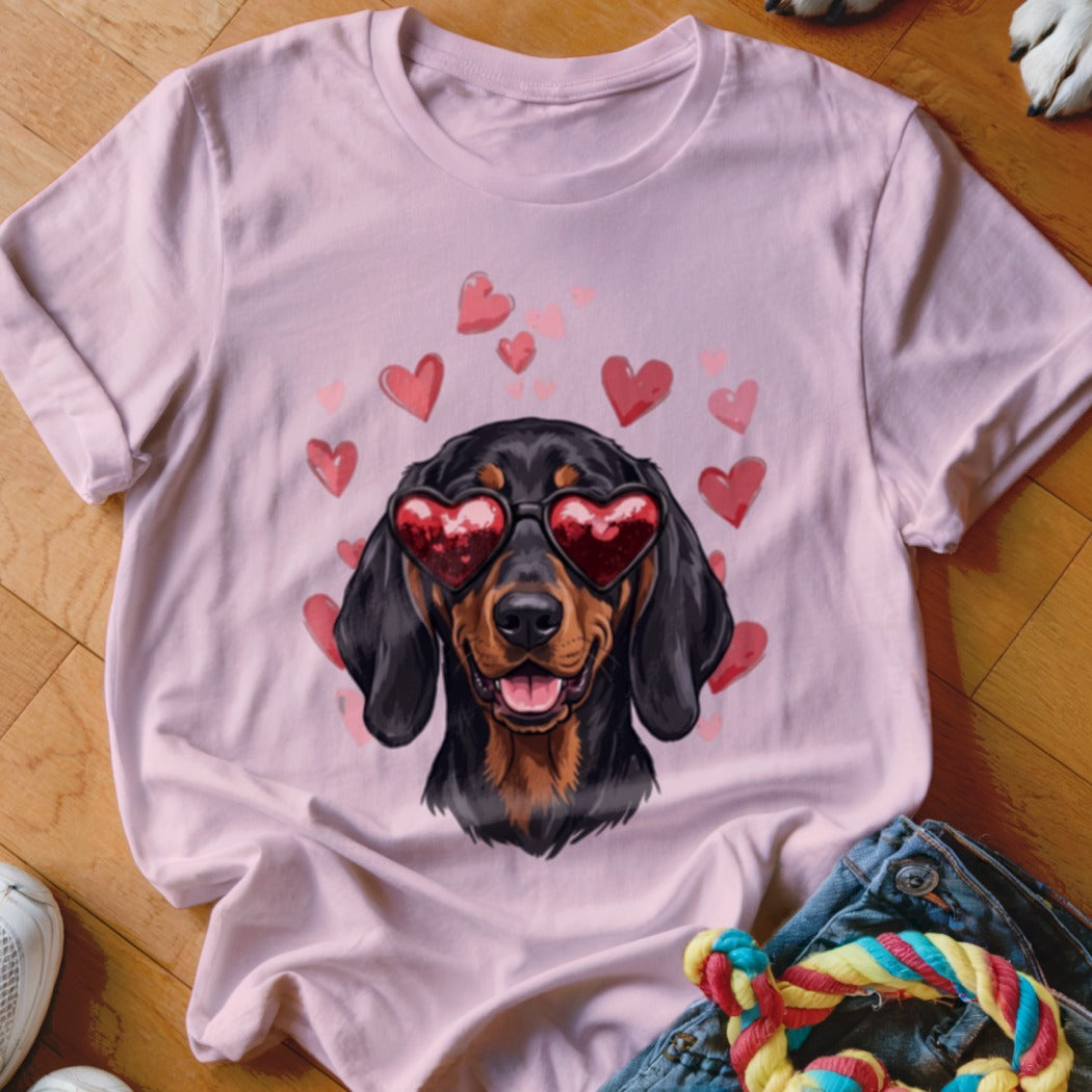 Pink t-shirt featuring a graphic of a dachshund wearing heart-shaped sunglasses surrounded by floating pink hearts.