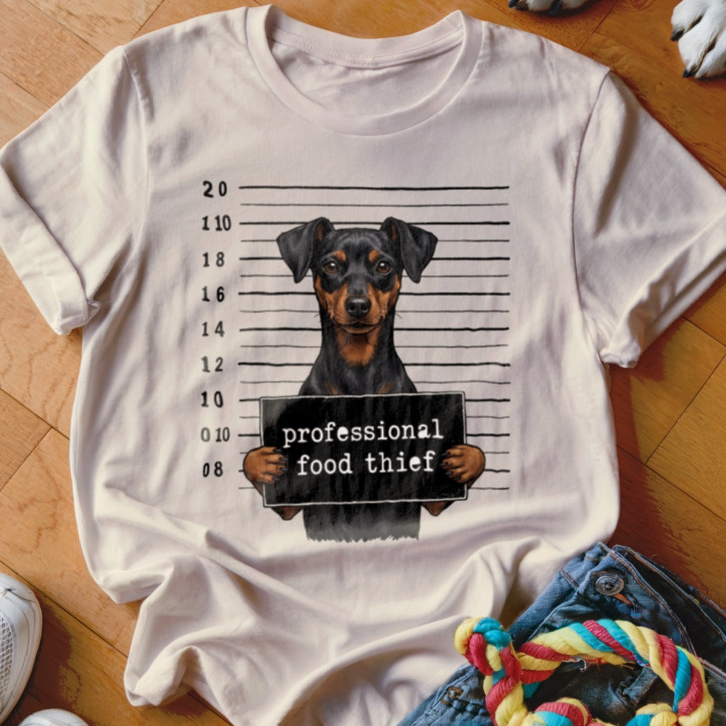 T-shirt graphic of a dog in a mugshot with "professional food thief" text.