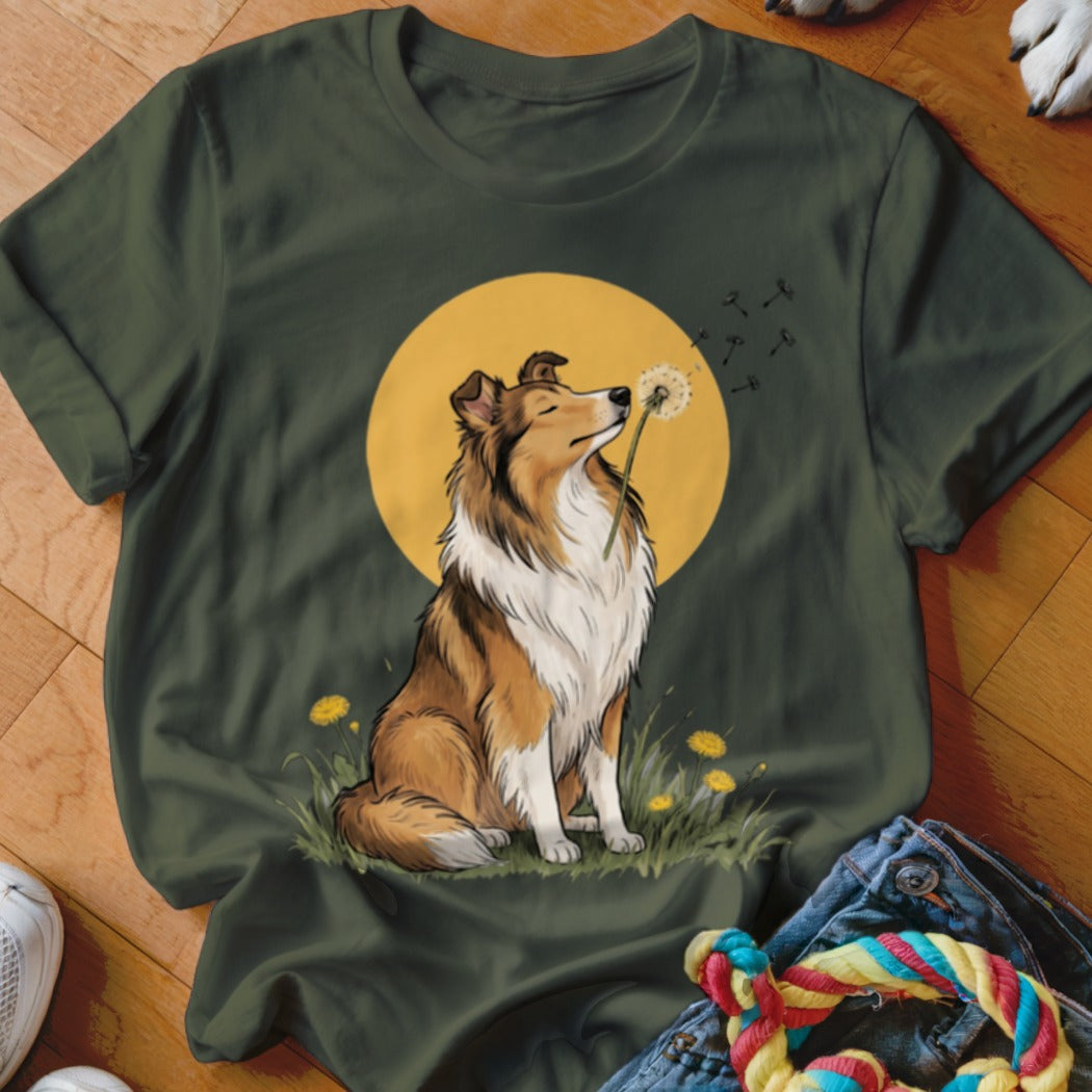 A dark green crewneck t-shirt featuring an illustration of a Collie dog sniffing a dandelion against a yellow circle.