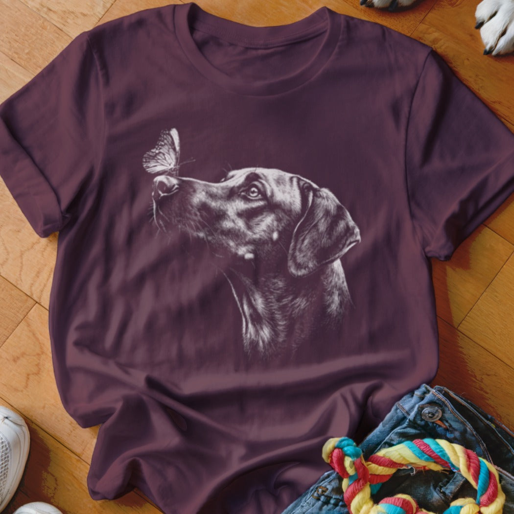 Maroon short-sleeved t-shirt featuring a white sketch graphic of a dog looking at a butterfly.