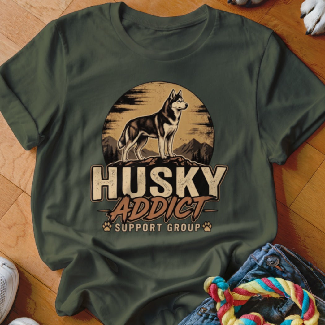 Olive green t-shirt featuring a graphic of a husky on a mountain with text reading HUSKY ADDICT SUPPORT GROUP.