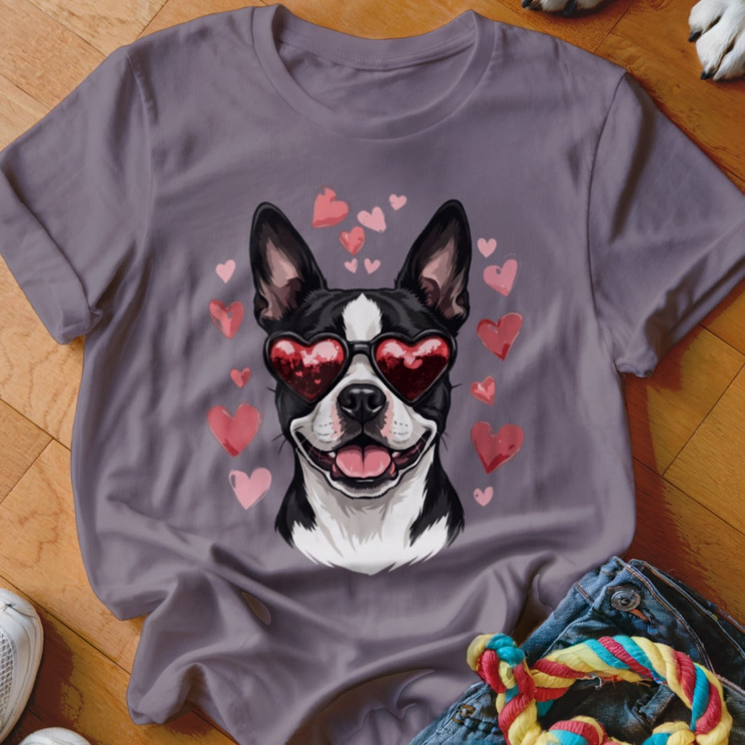 A grey t-shirt featuring a graphic of a Boston Terrier wearing heart-shaped sunglasses surrounded by floating pink hearts.