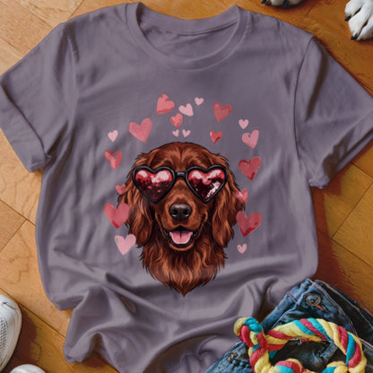A purple t-shirt featuring an illustration of a brown dog wearing heart-shaped sunglasses surrounded by floating pink hearts.