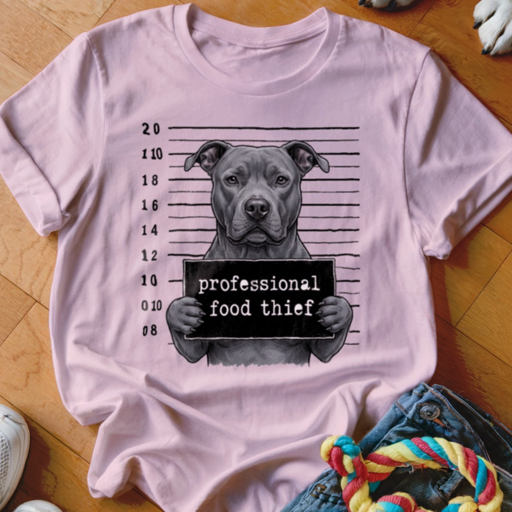 Pitbull mugshot graphic with text "professional food thief" on a pink t-shirt.