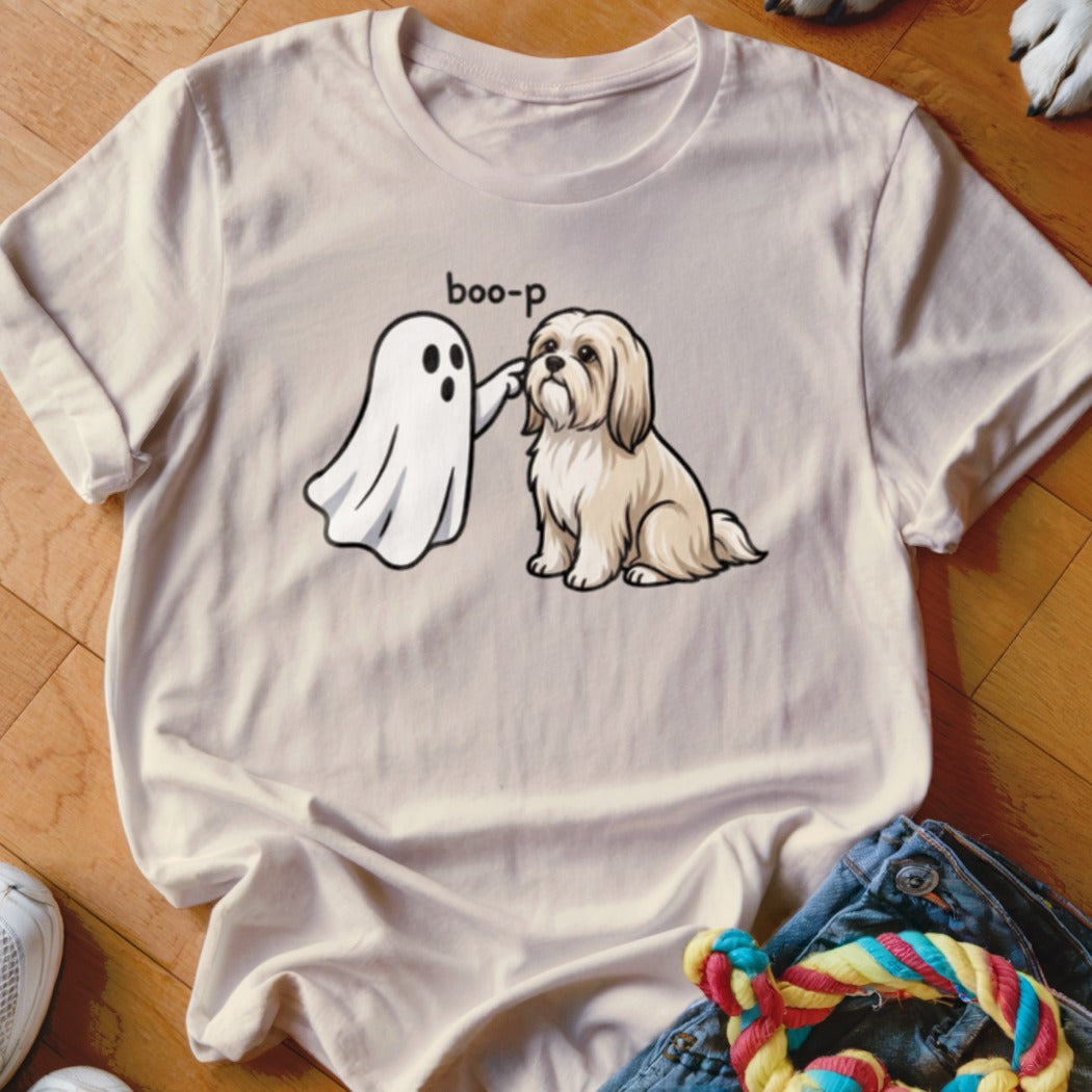 Ghost "boop-ing" a fluffy tan dog on a light cream t-shirt.