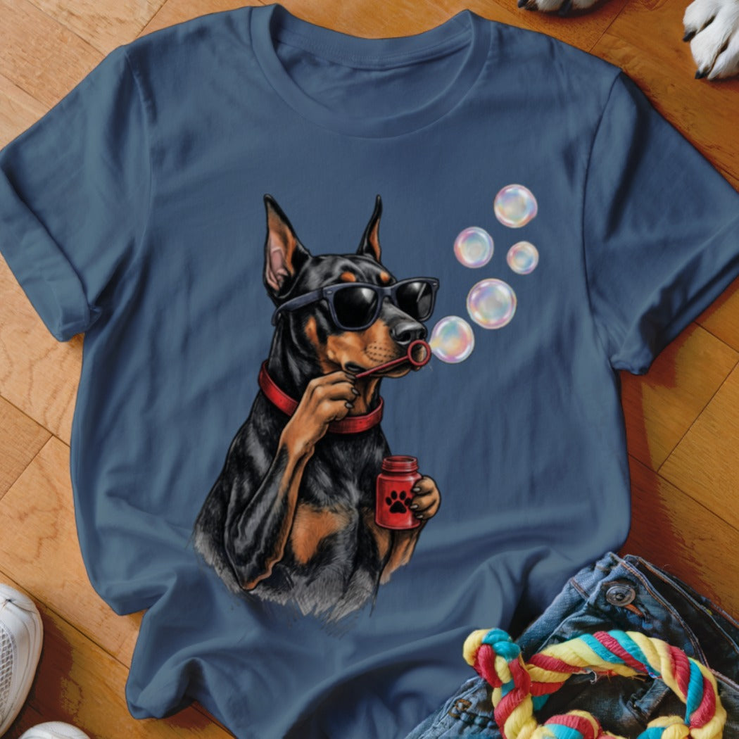 Blue t-shirt featuring an illustration of a Doberman wearing sunglasses and blowing bubbles.