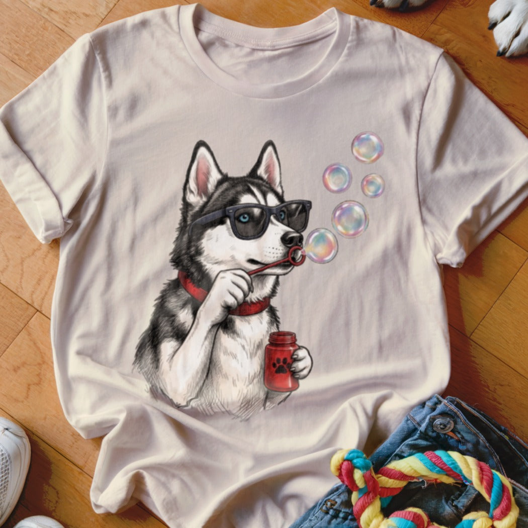 Beige t-shirt featuring an illustrated husky wearing sunglasses and blowing soap bubbles.