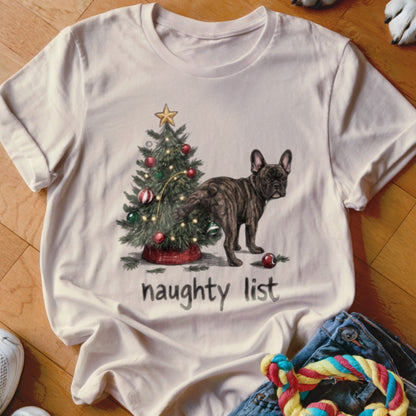 French Bulldog near a Christmas tree with the words "naughty list" printed below.