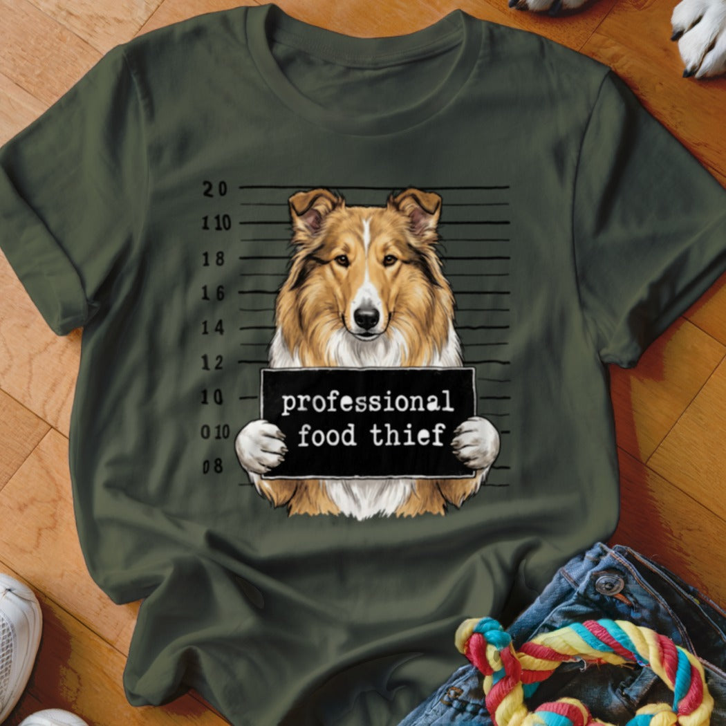 Collie dog mugshot holding a sign that says "professional food thief".