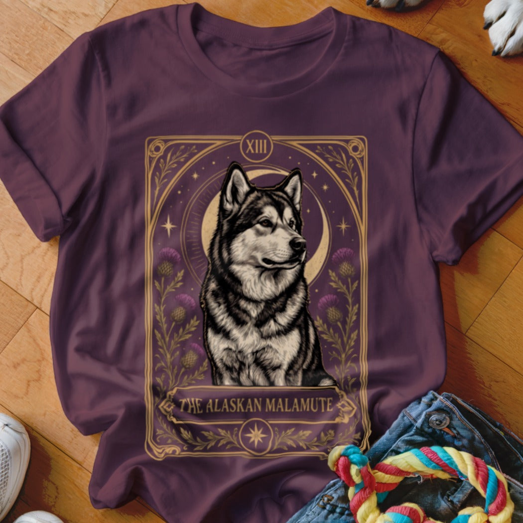 A dark purple t-shirt featuring a tarot card style graphic of an Alaskan Malamute.