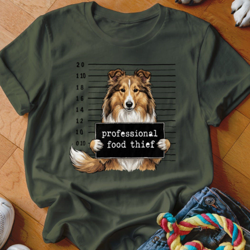 Shetland sheepdog mugshot with "professional food thief" sign.