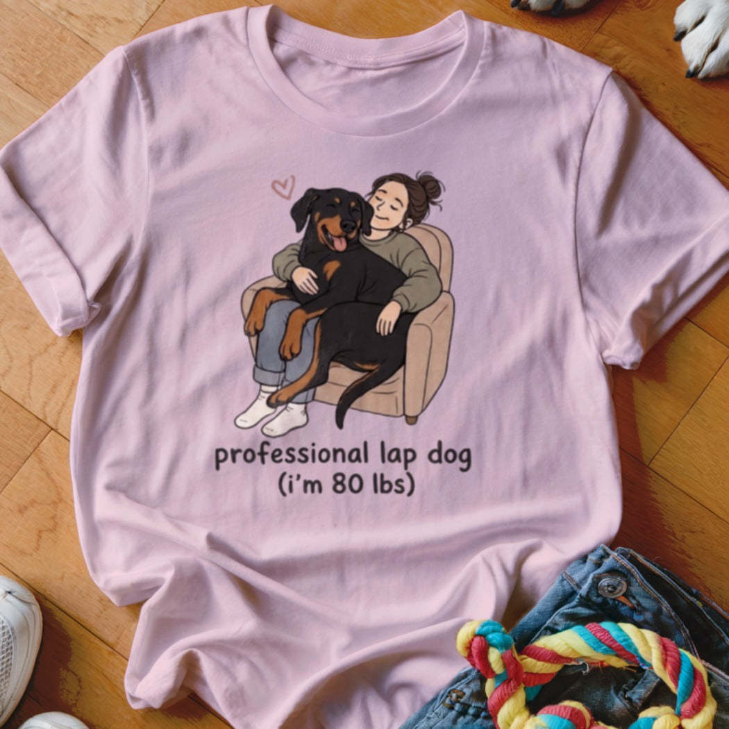 Pink t-shirt with graphic of person hugging a Rottweiler, reading "professional lap dog (i'm 80 lbs)".
