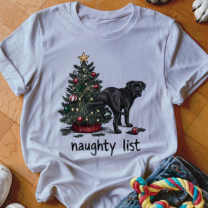 A white crewneck t-shirt featuring a graphic of a black dog peeing on a Christmas tree with text that says naughty list.
