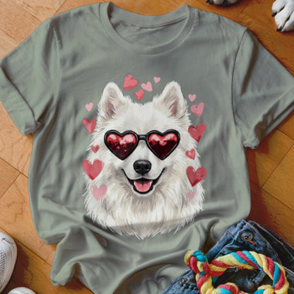An olive green t-shirt featuring a graphic of a white Samoyed dog wearing heart-shaped sunglasses, surrounded by pink hearts.