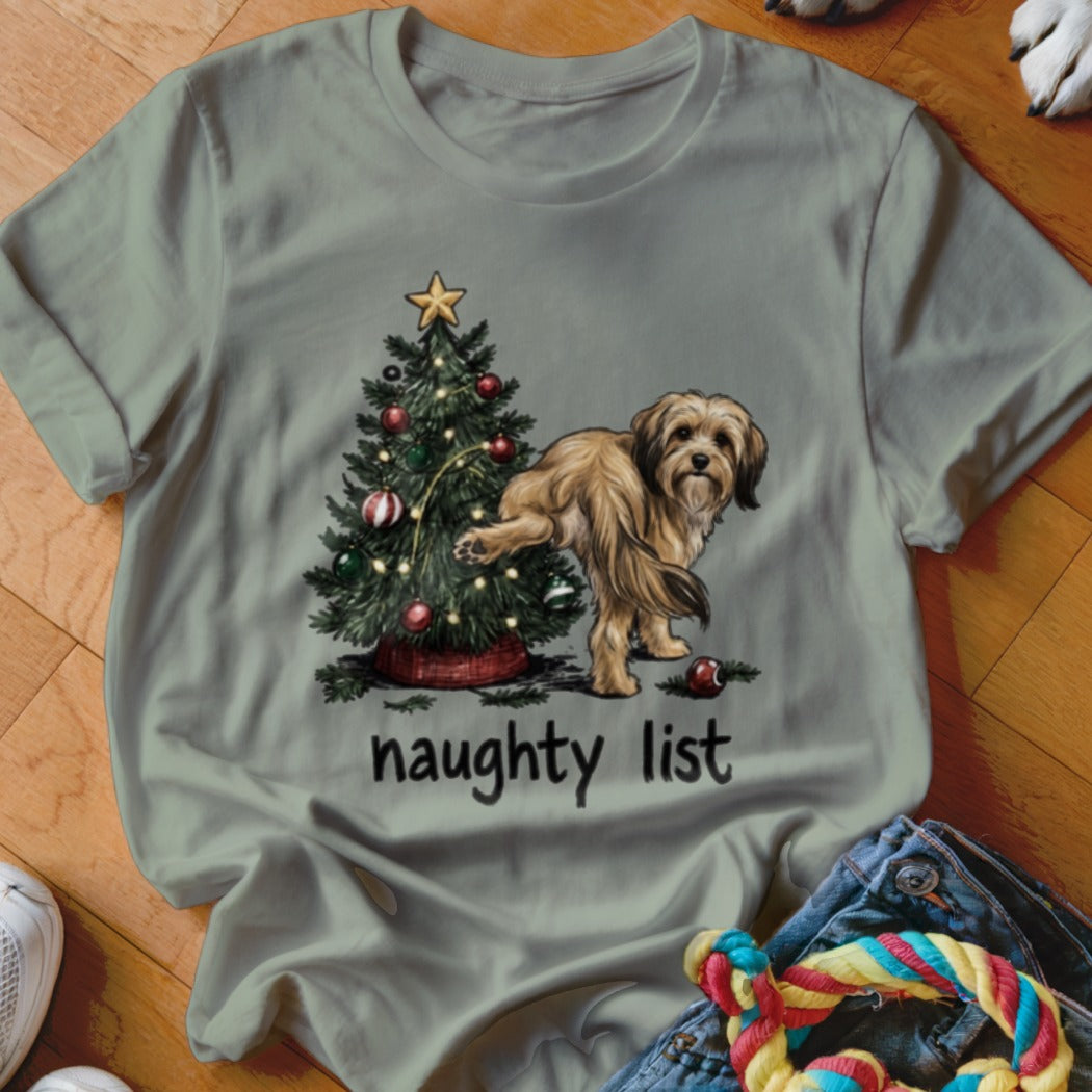 A dog lifts its leg on a Christmas tree with the words "naughty list" below.