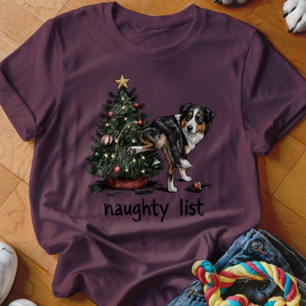Aussie dog lifting leg on Christmas tree with "naughty list" text.