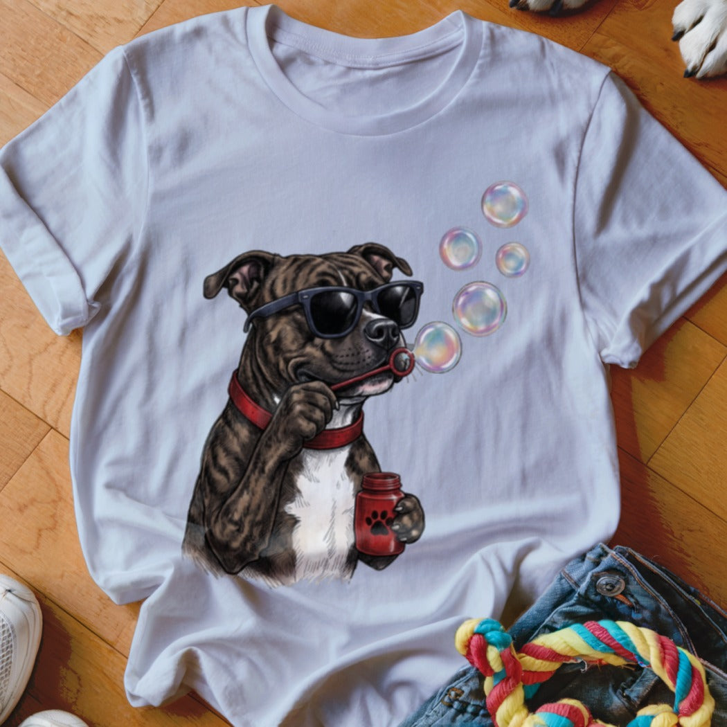 A white t-shirt featuring a graphic of a brindle dog wearing sunglasses and blowing soap bubbles.