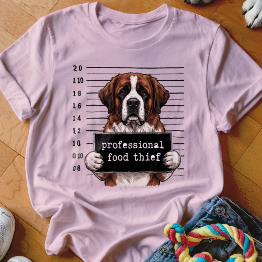 Saint Bernard dog mugshot with "professional food thief" text on a pink t-shirt.