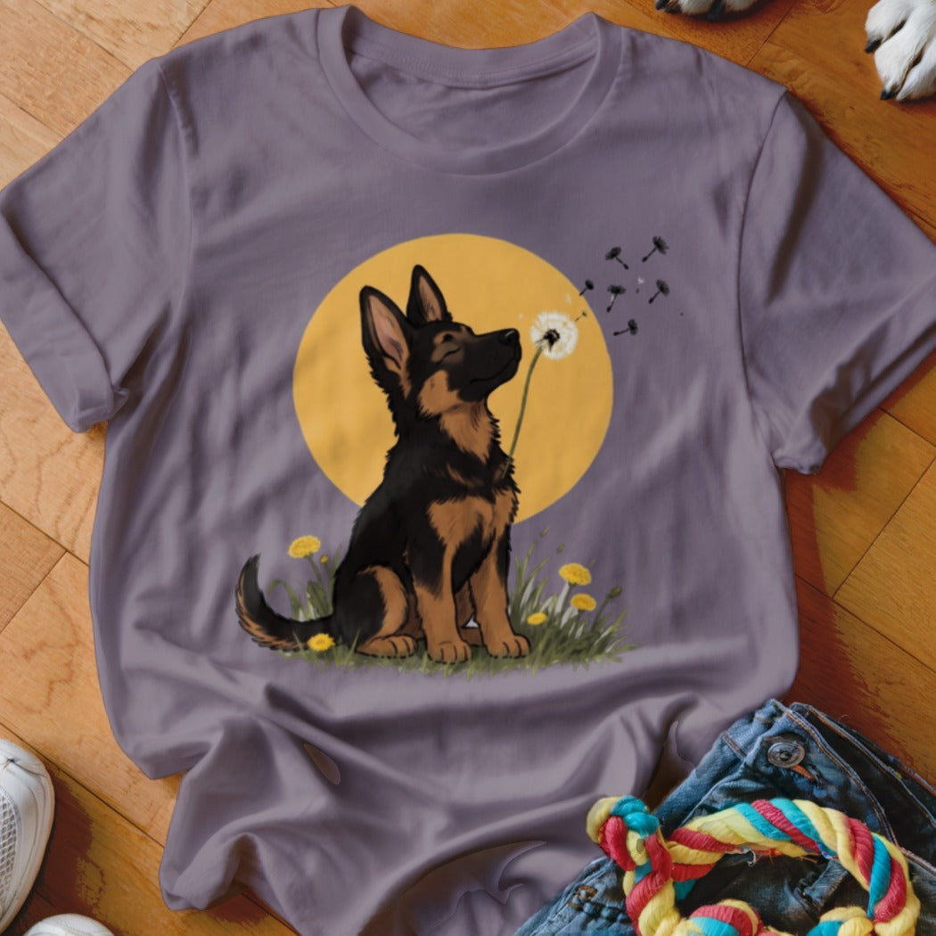 Gray short-sleeved t-shirt featuring a cartoon German Shepherd puppy sniffing a dandelion against a yellow sun.