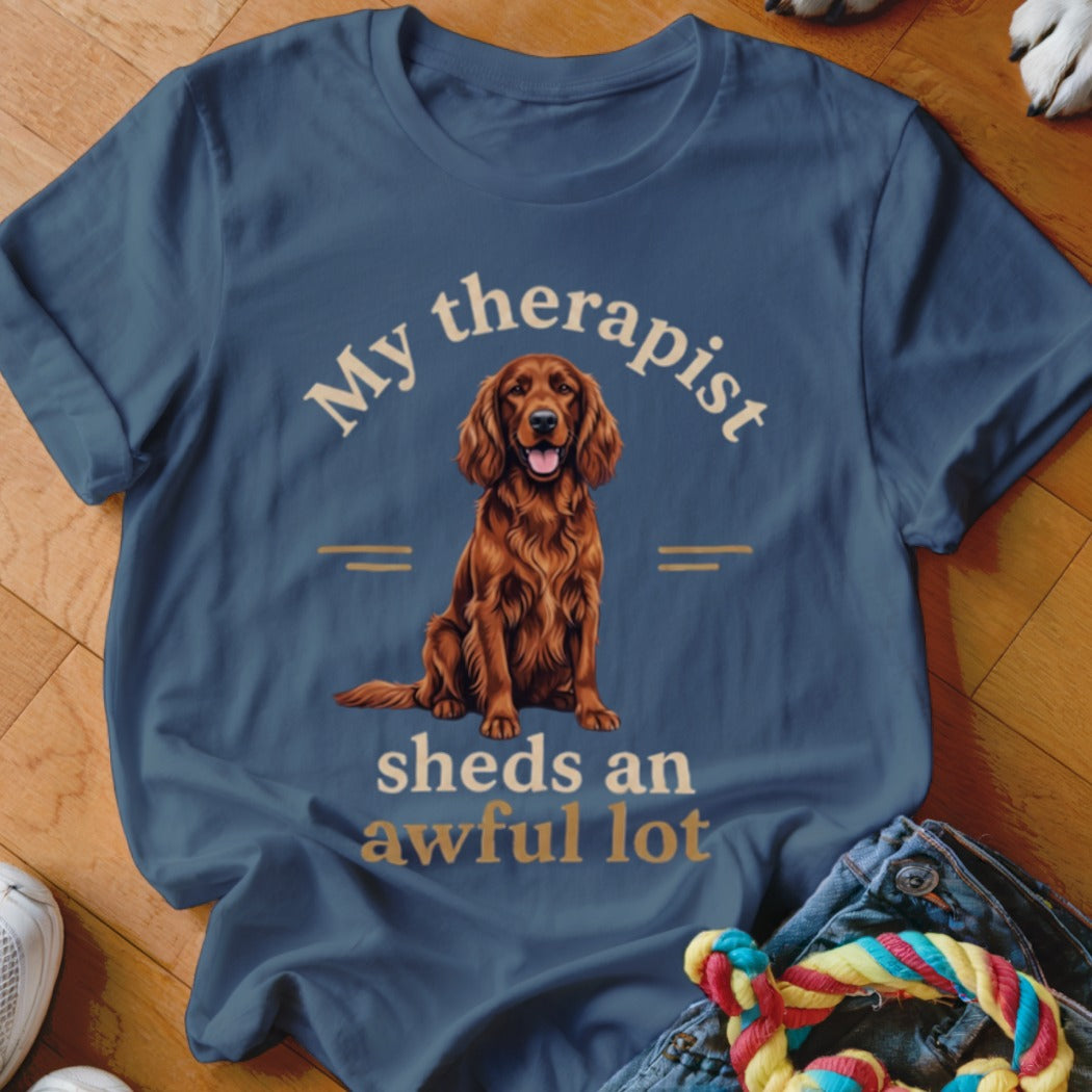 Blue t-shirt with a drawing of a reddish-brown dog and text: "My therapist sheds an awful lot."