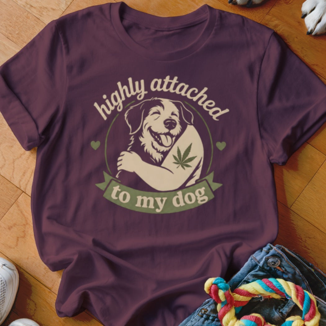 Maroon t-shirt with graphic of dog hugging a cannabis leaf, text "highly attached to my dog".