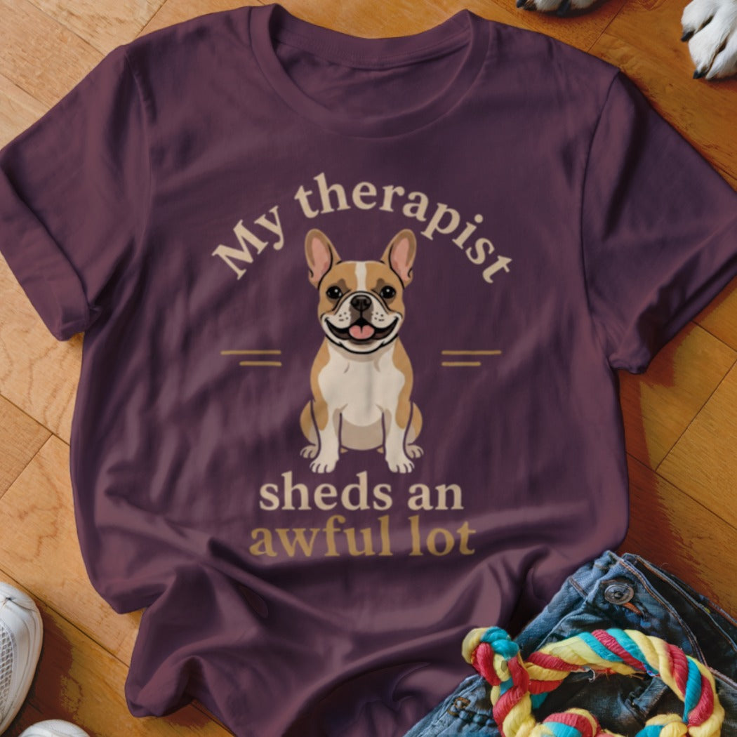 French bulldog wearing shirt with text "My therapist sheds an awful lot".