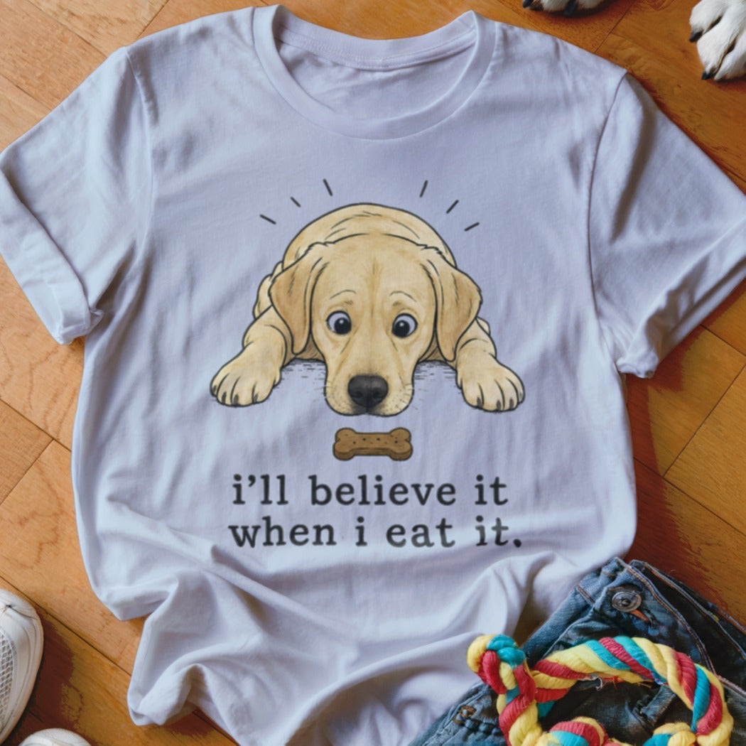 White t-shirt with cartoon dog and bone graphic with text "i'll believe it when i eat it."