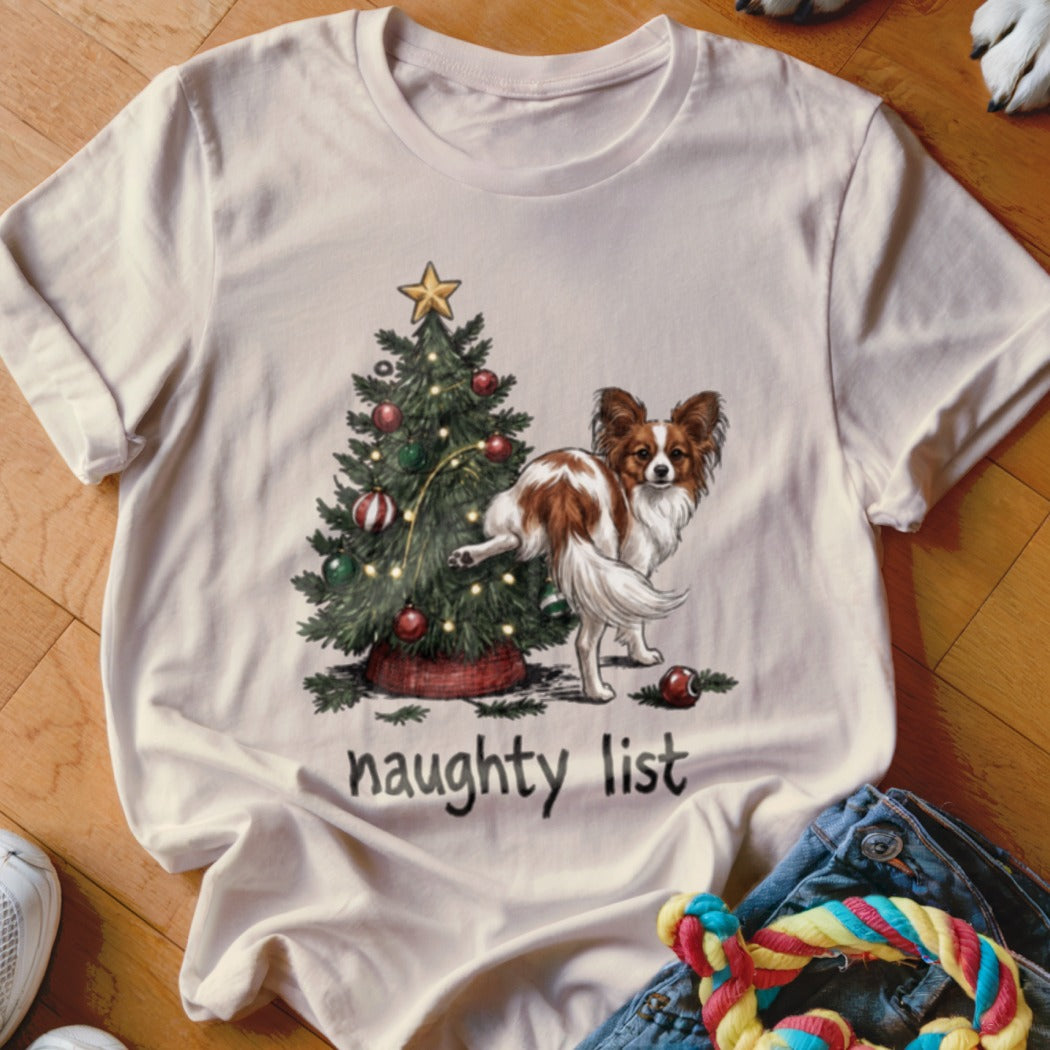 White t-shirt with a brown and white dog peeing on a Christmas tree, with "naughty list" text.