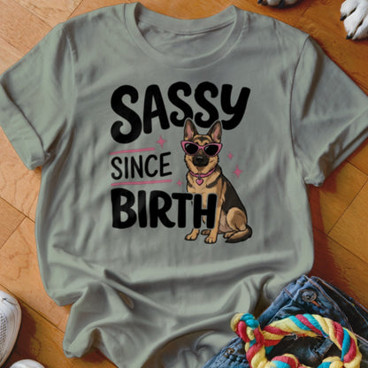 German Shepherd dog wearing sunglasses with text "Sassy Since Birth" on a t-shirt.