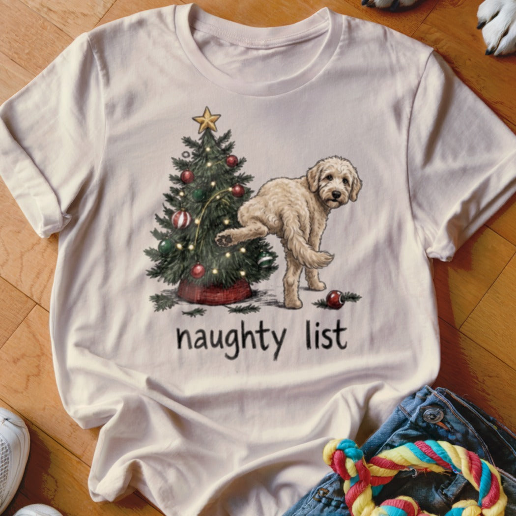 Cream t-shirt with a cartoon dog next to a Christmas tree with the words "naughty list".