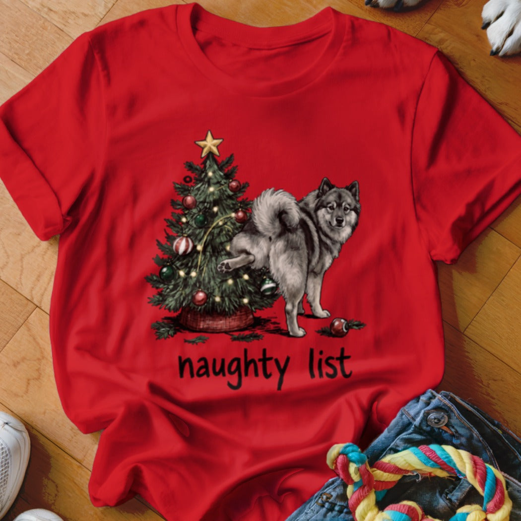 Red t-shirt with a dog by a Christmas tree and text that says "naughty list".