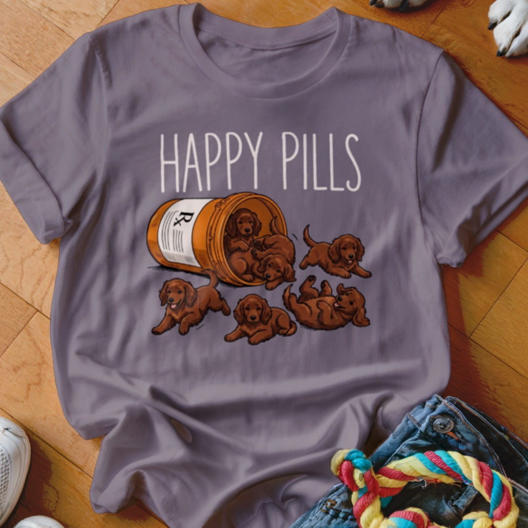 T-shirt graphic with text "HAPPY PILLS" above spilled prescription bottle with puppies.