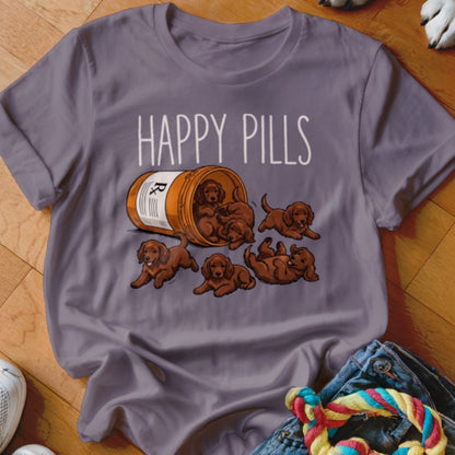 T-shirt graphic with text "HAPPY PILLS" above spilled prescription bottle with puppies.