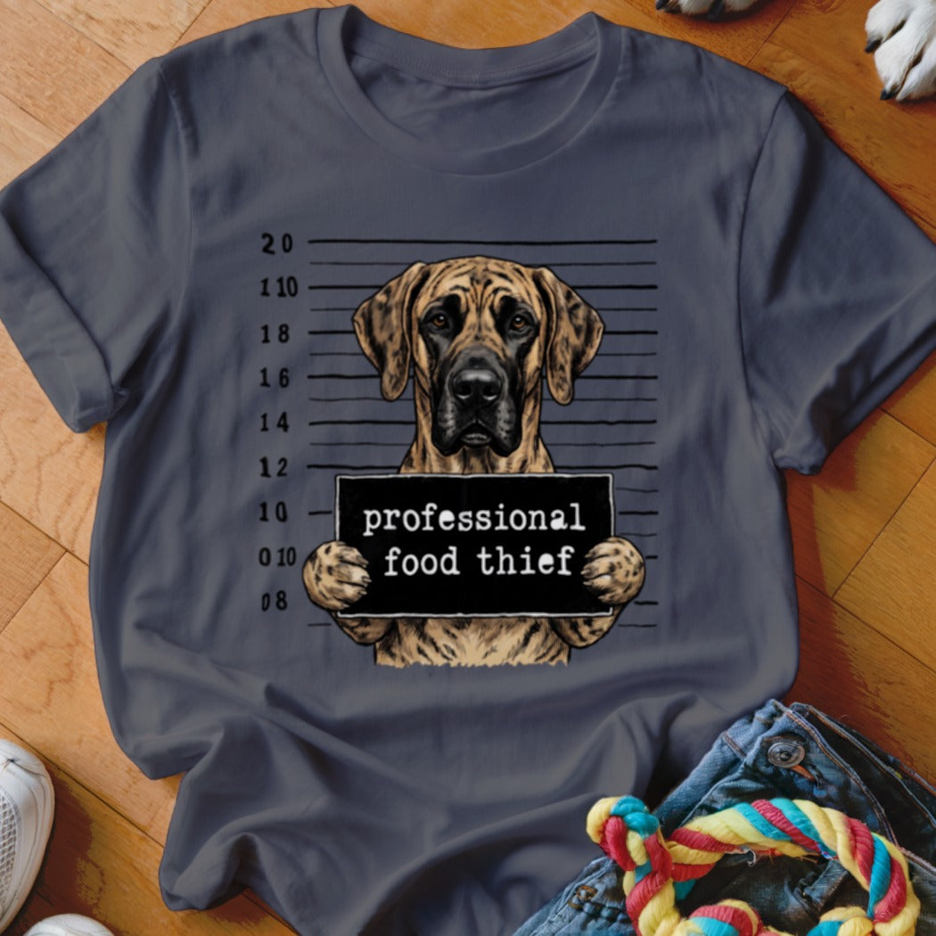 Great Dane mugshot with "professional food thief" sign on t-shirt.