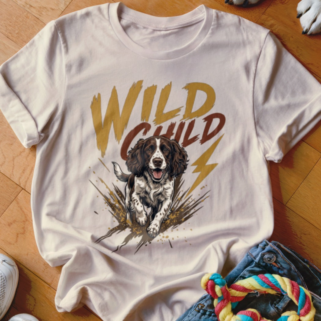 A cream-colored t-shirt with a graphic of a running spaniel and the text WILD CHILD.